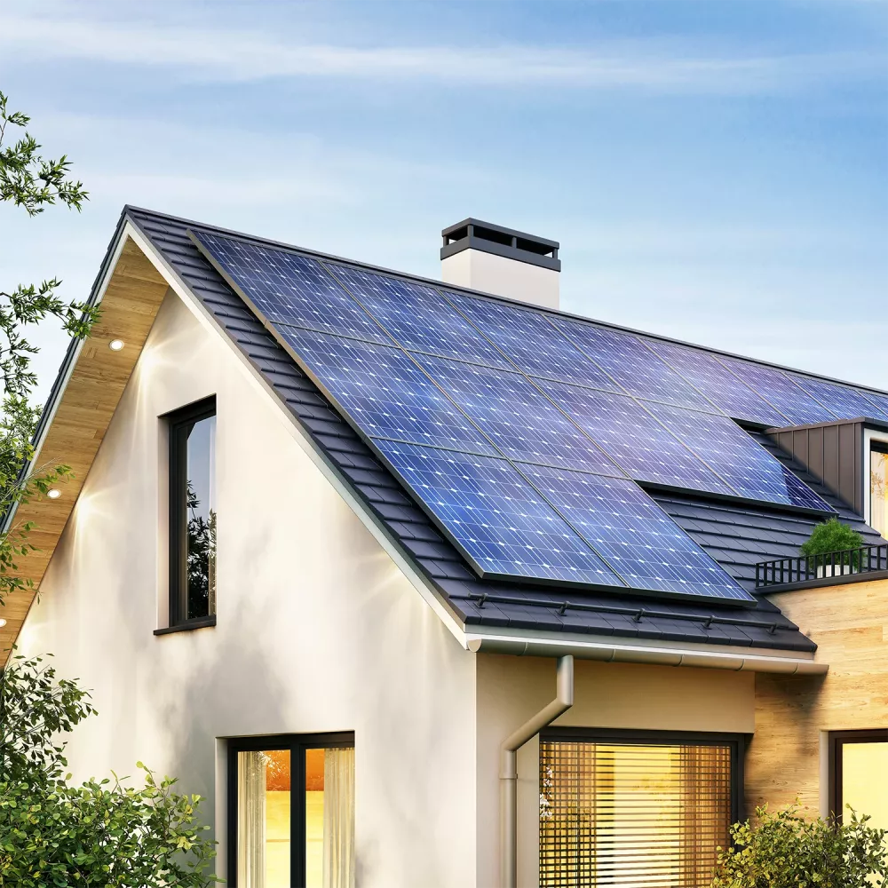 A captivating image displays a sleek, modern house with a striking black roof, donning a vibrant blue solar panel. The large window on the left and chimney on the right create a warm contrast, as lush greenery surrounds the eco-friendly abode, inviting natures beauty into view.